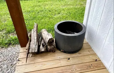 a bucket sitting on top of a wooden deck at Charming Cabin Surrounded by Woods and Fields in Oberlin, Ohio in Oberlin