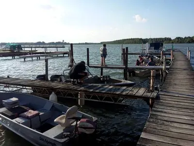 a group of people sitting at a dock with a boat at Secluded Cottage Rental in the Trees by Lake Erie, Ohio in Marblehead