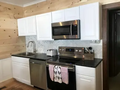 a kitchen with a stove and a microwave at Inviting Suite Rental in a Charming Farmhouse in Sandusky, Ohio in Sandusky