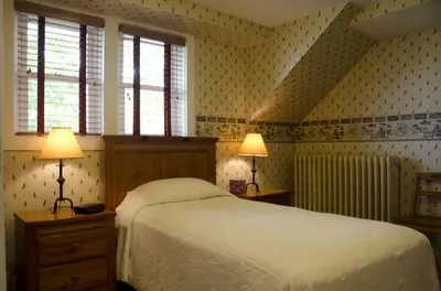 a bedroom with a bed and two lamps and two windows at Tranquil Weekend Getaway for a Large Group near the Cuyahoga Valley National Park, Ohio in Sandusky