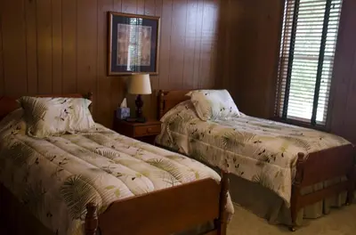 a bedroom with two beds and a table with a lamp at Tranquil Weekend Getaway for a Large Group near the Cuyahoga Valley National Park, Ohio in Sandusky