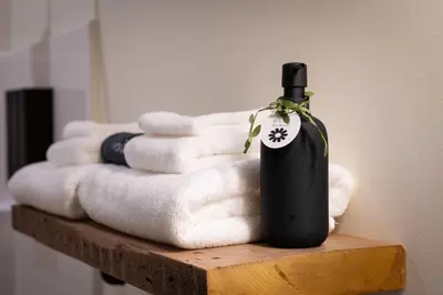 a bottle of wine sitting on a pile of towels at Courtyard King - Room 4 in Versailles