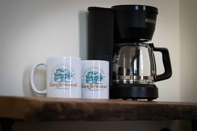two coffee mugs on a counter next to a coffee maker at Courtyard King - Room 4 in Versailles