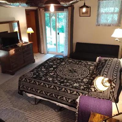 a bedroom with a bed and a dresser and a television at Country suite with bath and laundry in Athens