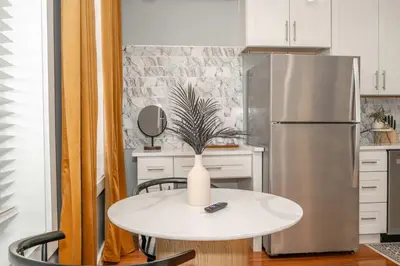 a kitchen with a white table and a refrigerator at Findlay Market - Suite 4 for 2 in Cincinnati