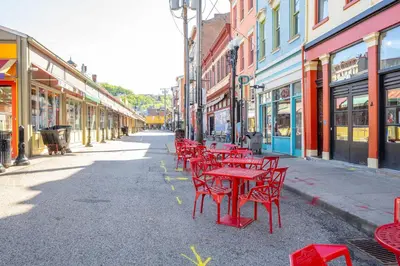 a row of red tables and chairs on a city street at Findlay Market - Suite 4 for 2 in Cincinnati