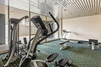 a gym with treadmills and elliptical machines at Suburban Studios Charleston - Civic Center in Charleston
