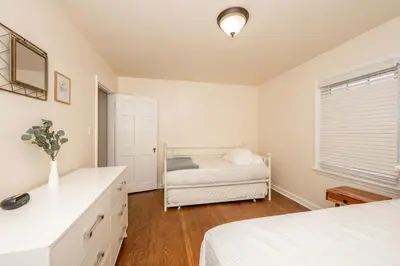 a white bedroom with a bed and a window at Kenwood Keys Suites - for 12 in Cincinnati