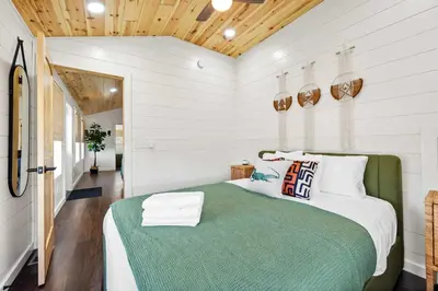 a bedroom with a large bed with a green blanket at The Lodges at Eden Reserve - Cabin Loop - Near Ark in Williamstown