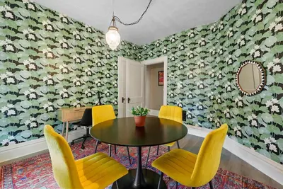 a dining room with a table and yellow chairs at Merion Village Residences Suites in Columbus