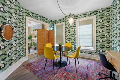 a dining room with a table and yellow chairs at Merion Village Residences Suites in Columbus