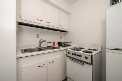 a white kitchen with a sink and a stove at Northside Suites - 4 Apartments in Cincinnati