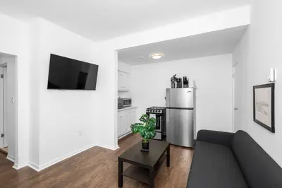 a living room with a couch and a refrigerator at Northside Suites - 4 Apartments in Cincinnati