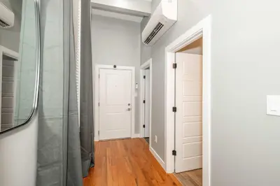 a hallway with white walls and a glass door at Findlay Market Suite 1 - For 2 in Cincinnati