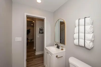 a white bathroom with a sink and a mirror at The LUXE Spot 1 in Covington