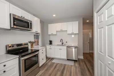 a kitchen with white cabinets and stainless steel appliances at LUXE Spot Suites in Covington