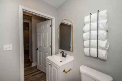 a white bathroom with a sink and a mirror at LUXE Spot Suites in Covington