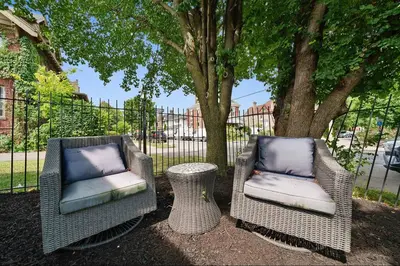 two wicker chairs and a table in front of a tree at Chic City Retreat 87 in Columbus