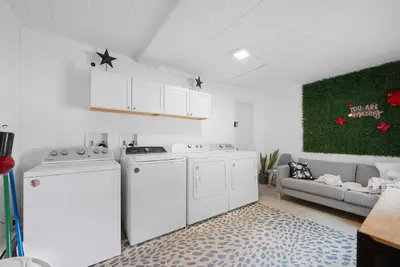 a laundry room with white appliances and a couch at Chic City Retreat 93D in Columbus