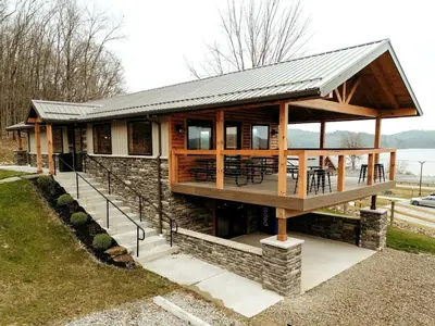 a house with a deck with tables and chairs at Amazing A-Frame by Tappan Lake Perfect for Outdoor Lovers in Ohio in Deersville