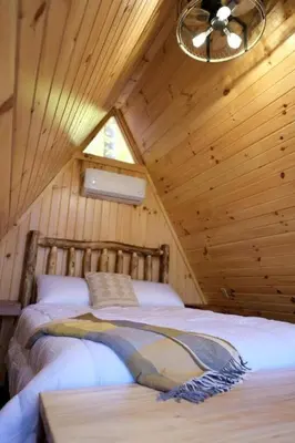 a bedroom with a bed in a wooden cabin at Amazing A-Frame by Tappan Lake Perfect for Outdoor Lovers in Ohio in Deersville