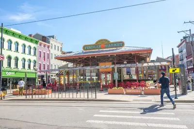 a man crossing a street in front of a building at Findlay Market Suite 3 - For 2 in Cincinnati