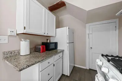 a kitchen with white cabinets and a white refrigerator at Tibet Twins 1 Cozy Stay for 6 in Columbus