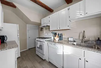 a kitchen with white cabinets and a stove top oven at Tibet Twins 1 Cozy Stay for 6 in Columbus