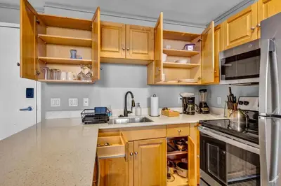 a kitchen with wooden cabinets and stainless steel appliances at Downtown Cleveland Loft Near CSU, Playhouse, Arena in Cleveland