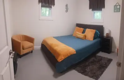 a bedroom with a blue bed and a chair at The Reel Freedom Cottage at Leesville Lake in Carrollton