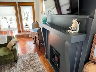 a living room with a fireplace and a tv at Fiesinger House - Private 1-bd unit, Historic Home Downtown Sandusky in Sandusky