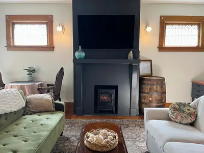 a living room with a couch and a fireplace at Fiesinger House - Private 1-bd unit, Historic Home Downtown Sandusky in Sandusky