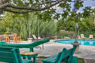 a pool with green chairs and a table and chairs at Resort Cabin 1 Mi to Middle Bass Island State Park in Middle Bass