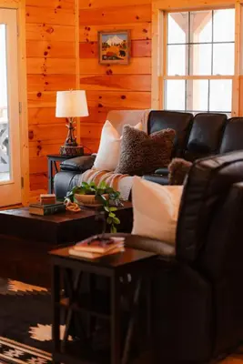 a living room with a couch and a table at Sleeps 16 Luxury Cabin with Game Room & Hot Tub in Logan