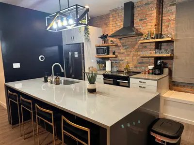 a kitchen with a large white island in a room at Jungle House Columbus Downtown Free Parking Sleeps 8 - Steps to Convention Center & Nationwide Arena - 2BR Short North Luxury Home - Over 5,800 Five Star Stays in Columbus