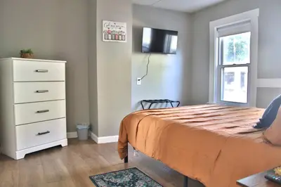 a bedroom with a bed and a dresser and a window at Lakewood Entire Home! Sleeps 10! in Lakewood