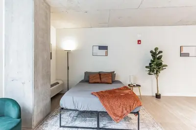 a bedroom with a bed and a blue chair at 2 New Studios with Stunning City Views in Cleveland