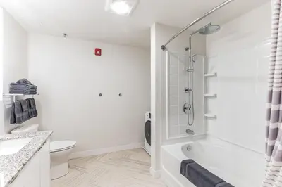 a white bathroom with a shower and a toilet at 2 New Studios with Stunning City Views in Cleveland