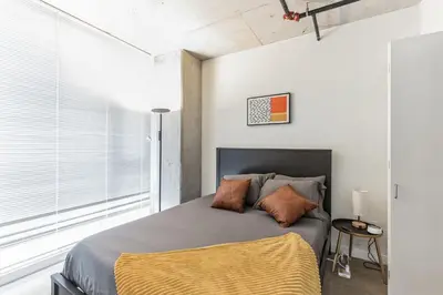 a bedroom with a bed and a large window at 10 Brand new combined apartments with city views in Cleveland