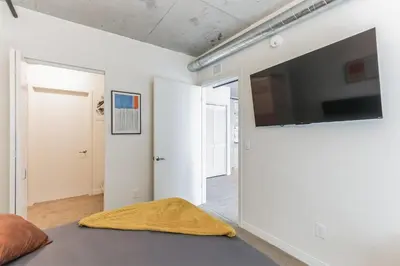 a living room with a flat screen tv on a wall at 10 Brand new combined apartments with city views in Cleveland