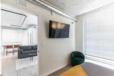 a living room with a couch and a television on a wall at 2 Centrally Located DT Luxury studios at City Club in Cleveland