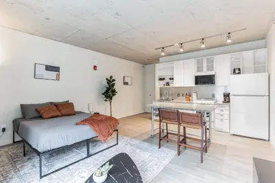 a bedroom with a bed and a kitchen in it at 2 Centrally Located DT Luxury studios at City Club in Cleveland