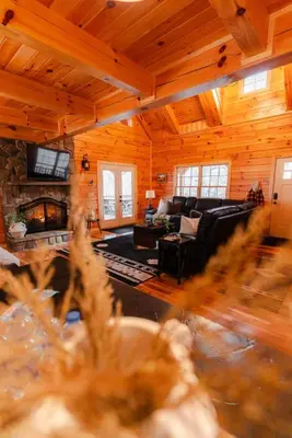 a living room with a couch and a fireplace at Sleeps 16! Luxury Cabin with Game Room & Hot Tub in Nelsonville