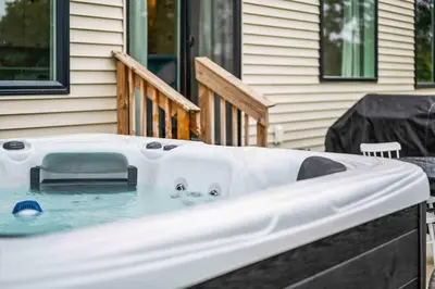 a hot tub in front of a house at 3 Homes, 3 Hot Tubs, 10BR, 10 Bath, Near Ark! in Dry Ridge