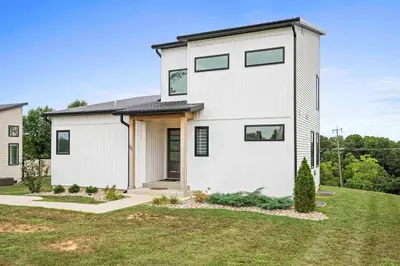 a white house with a black roof at 3 Homes, 3 Hot Tubs, 10BR, 10 Bath, Near Ark! in Dry Ridge