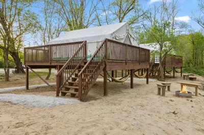 a yurt on a playground with stairs and a fire at Furnished Glamping Tent/River Access/2 Queen Beds in Stanton