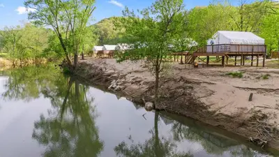 a view of a river with a building and trees at Furnished Glamping Tent/River Access/2 Queen Beds in Stanton