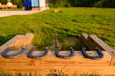 a wooden boat with black horseshoes in a field at Furnished Glamping Tent/Red River Access/King Bed in Stanton