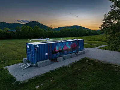 a container with graffiti on it sitting in a field at Glamping Tent/Red River Access/2 Queen Beds in Stanton