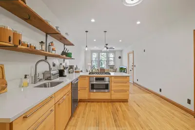 a large kitchen with wooden cabinets and a sink at Spacious Historic 8-Bedroom Manor in Short North - Perfect for Large Groups in Columbus